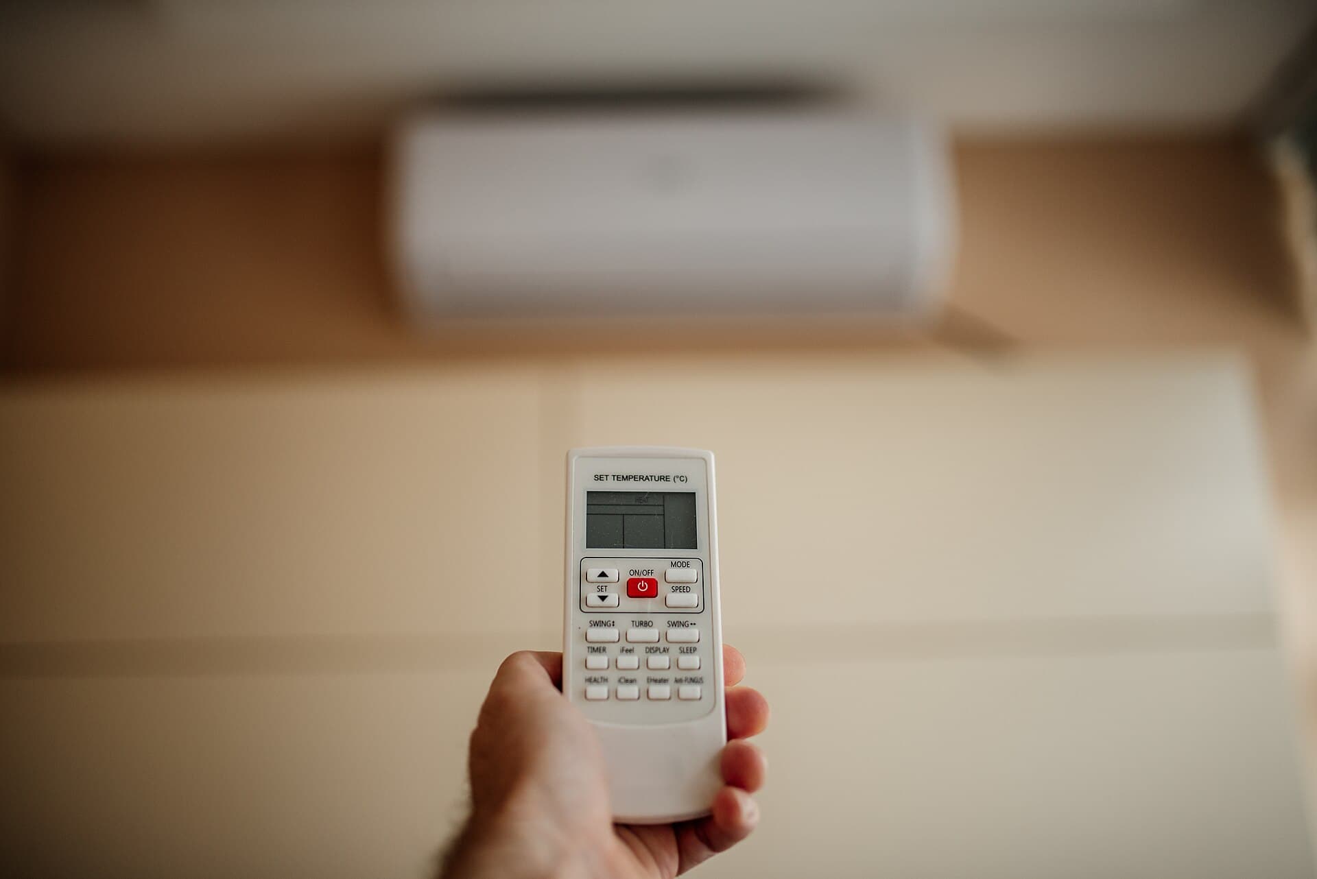 Mando del aire acondicionado ajustando la temperatura